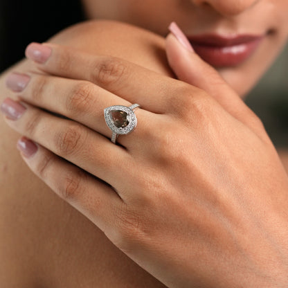 Close-up of a woman's hand wearing a diamond ring with a blurred background