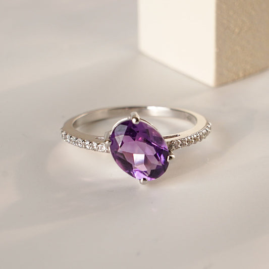 An oval-shaped amethyst ring with a silver band.