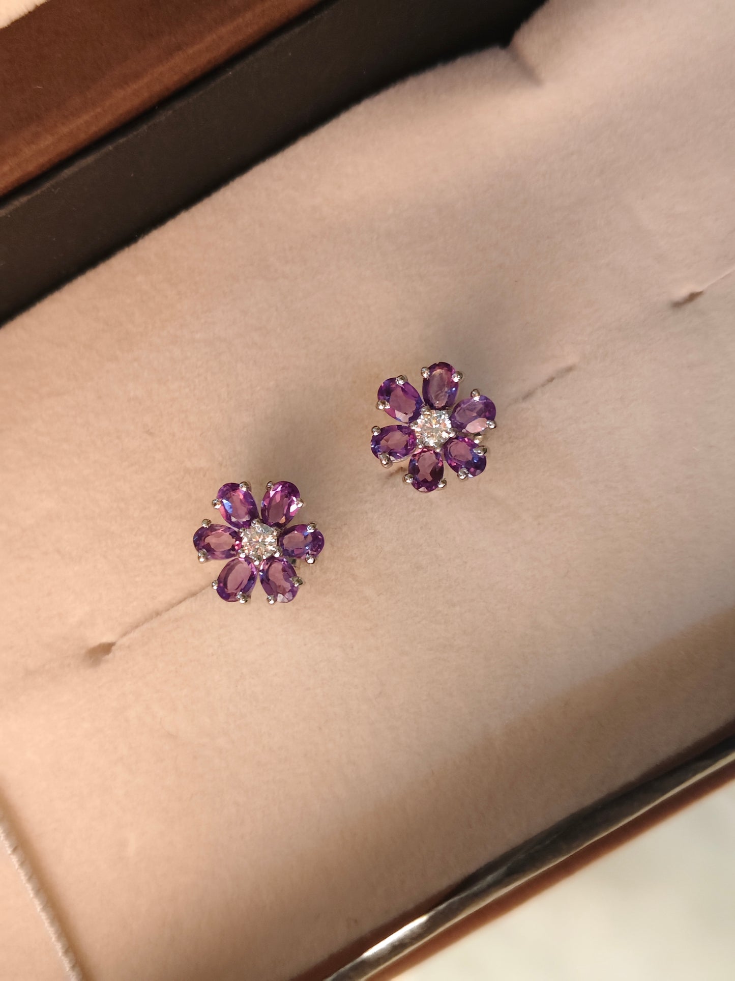 Pair of purple flower-shaped earrings on a soft surface