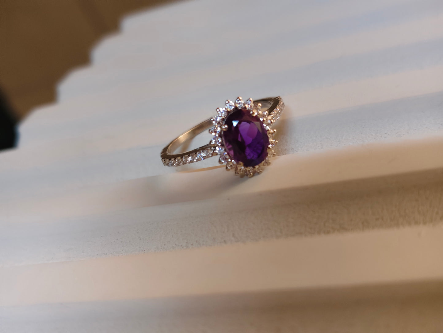 Ring with a purple gemstone on a white fabric background