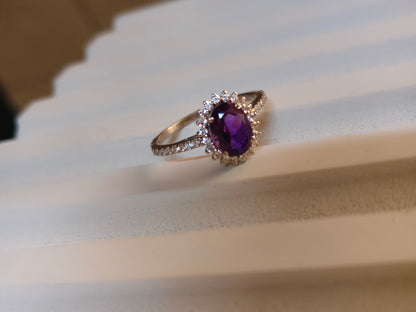 Ring with a purple gemstone on a white fabric background