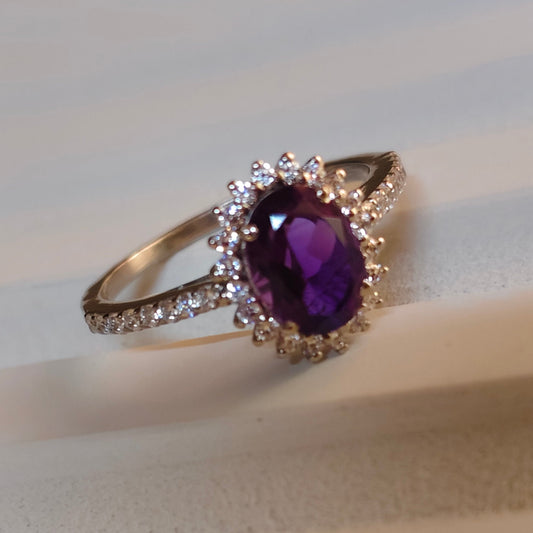 Ring with a purple gemstone on a white fabric background