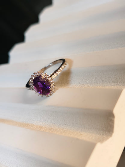 Ring with a purple gemstone on a white fabric background
