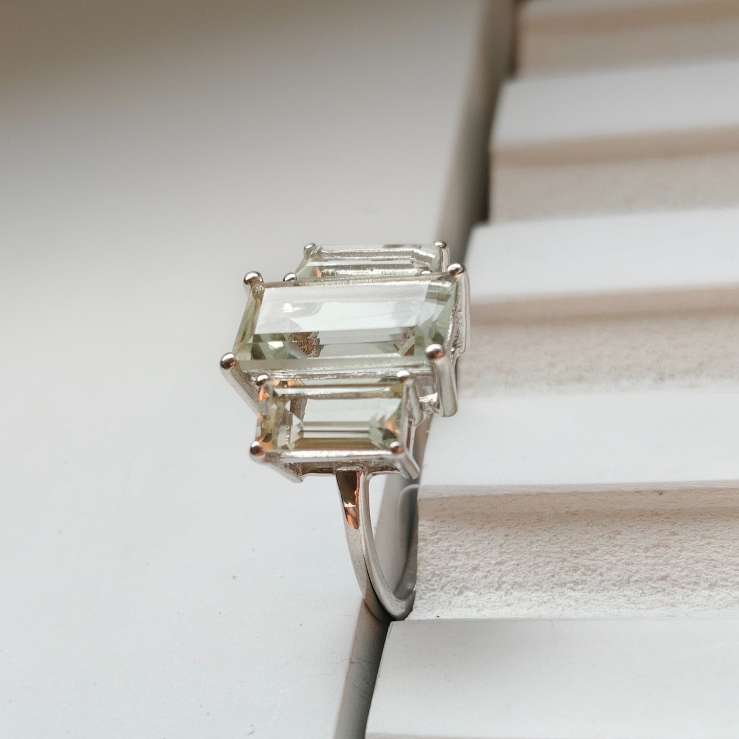 Silver ring with a green gemstone on a textured surface