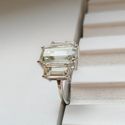 Silver ring with a green gemstone on a textured surface
