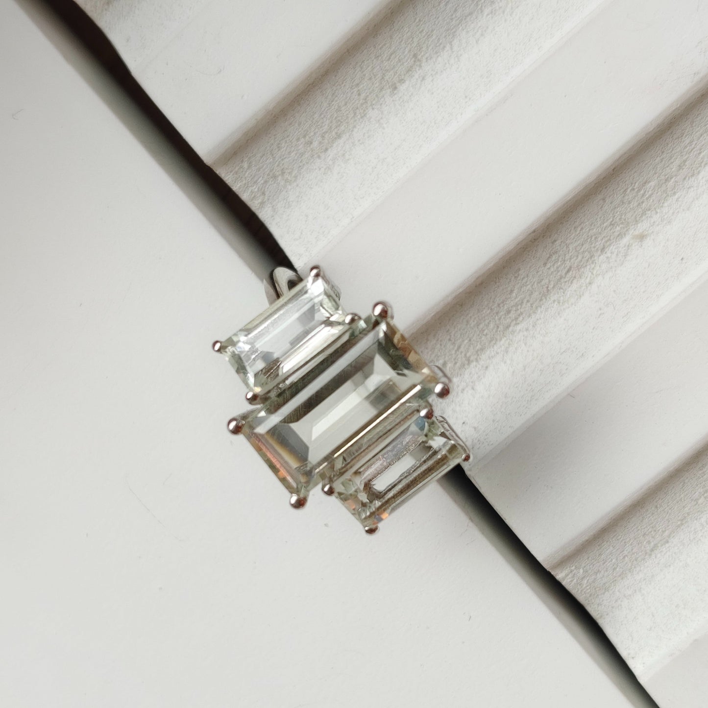 Silver ring with a clear gemstone on a white background