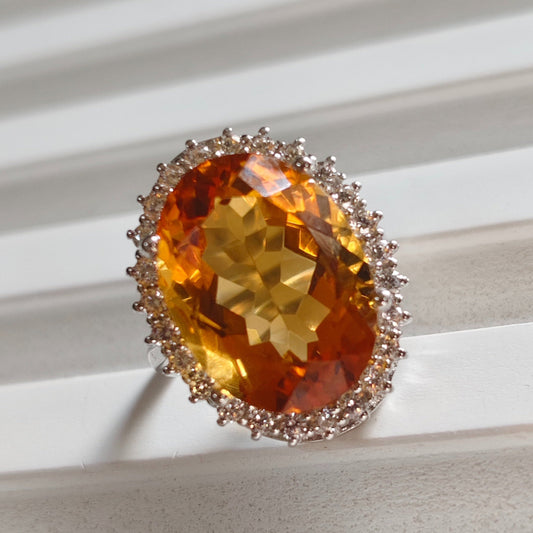 Ring with a large orange gemstone on a white surface