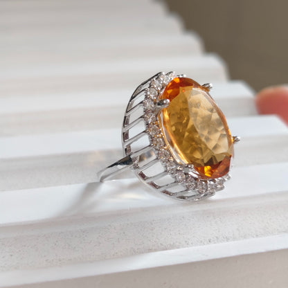 Ring with a large orange gemstone on a white surface