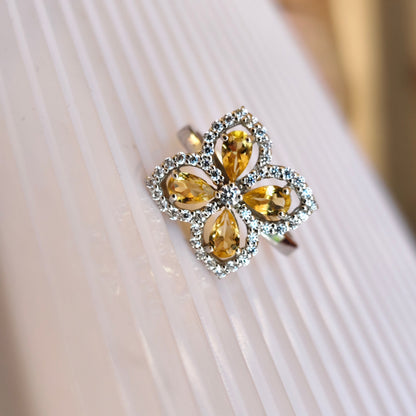 Ring with yellow gemstones on a white fabric background