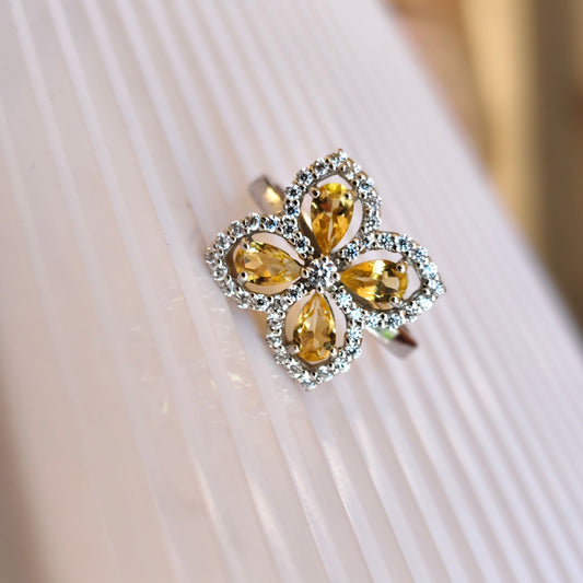 Ring with yellow gemstones on a white fabric background