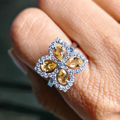 Close-up of a ring with pear-shaped gemstones on a finger